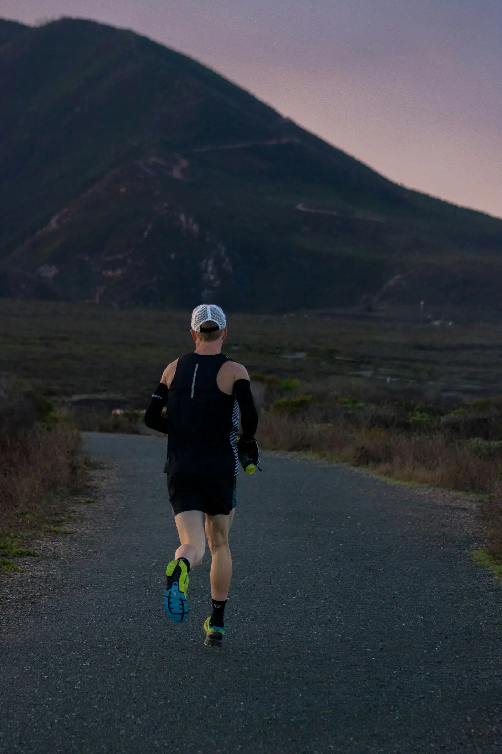 A woman jogging outdoors on a mountain road